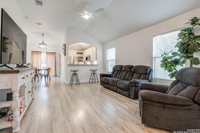 living room featuring ceiling fan, a healthy amount of sunlight, light wood-type flooring, and lofted ceiling