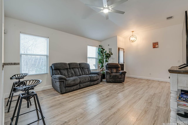 living room featuring a healthy amount of sunlight, light hardwood / wood-style flooring, vaulted ceiling, and ceiling fan