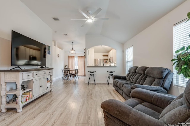 living room featuring light hardwood / wood-style floors, ceiling fan, and vaulted ceiling