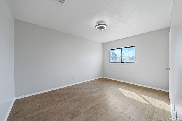 empty room with hardwood / wood-style flooring