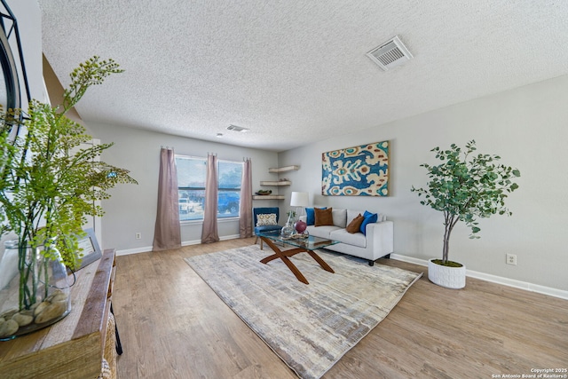 living room featuring a textured ceiling and light wood-type flooring