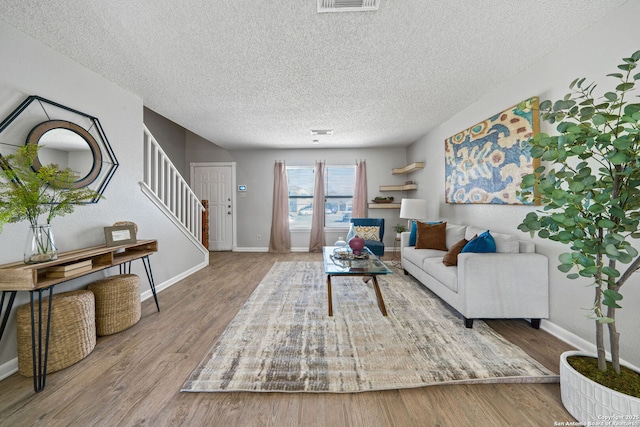 living room featuring a textured ceiling and wood-type flooring