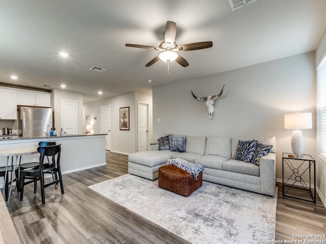 living room with ceiling fan and wood-type flooring