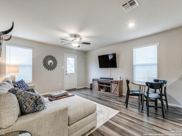 living room featuring wood-type flooring and ceiling fan