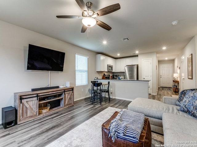 living room featuring ceiling fan and wood-type flooring