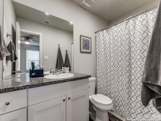 bathroom featuring vanity, toilet, and ceiling fan