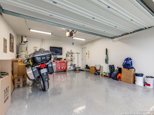 garage featuring electric panel, water heater, and a garage door opener