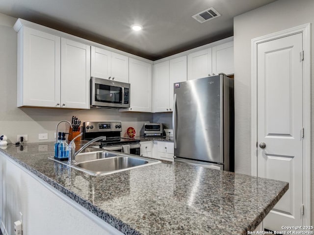 kitchen featuring kitchen peninsula, white cabinetry, and appliances with stainless steel finishes