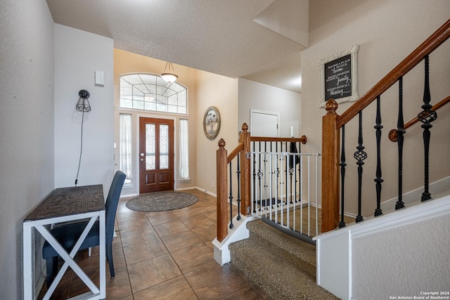 tiled foyer entrance with a textured ceiling