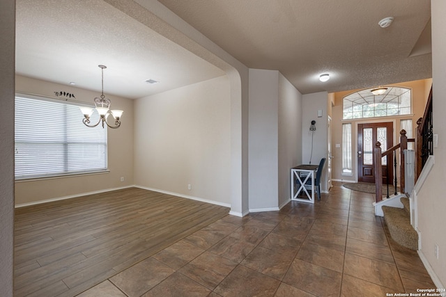 entryway featuring a notable chandelier and a textured ceiling