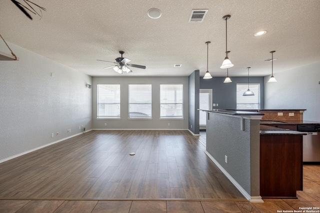 kitchen with a healthy amount of sunlight, dark wood-type flooring, dishwasher, and hanging light fixtures