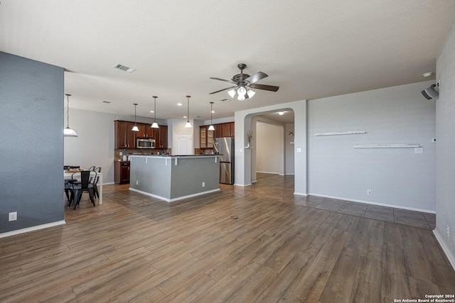 unfurnished living room with ceiling fan and dark hardwood / wood-style flooring