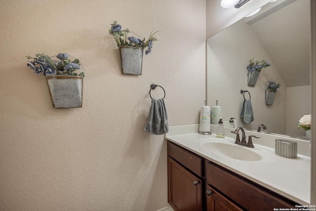 bathroom featuring vaulted ceiling and vanity