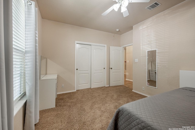 carpeted bedroom featuring ceiling fan and a closet