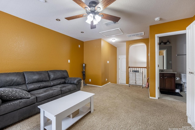 living room featuring light carpet, a textured ceiling, and ceiling fan