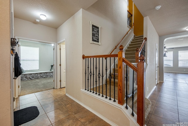 interior space with a textured ceiling and tile patterned floors