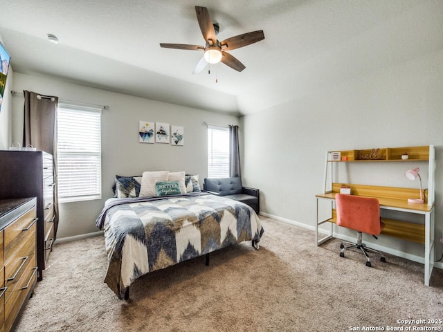 bedroom with ceiling fan, light colored carpet, vaulted ceiling, and multiple windows