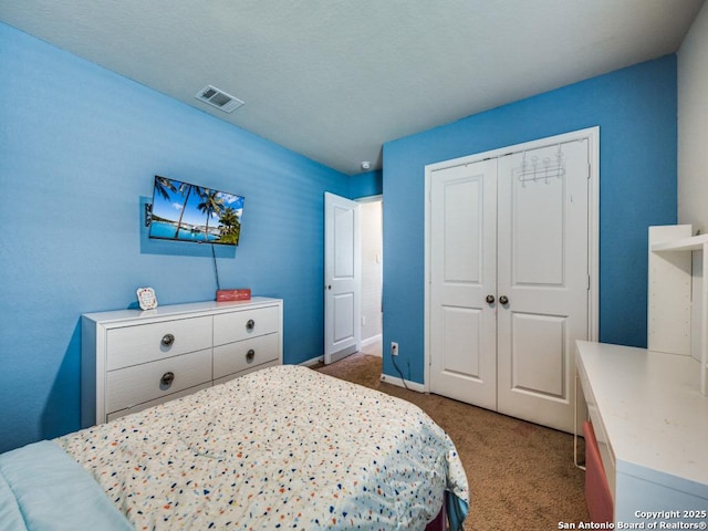 bedroom featuring a closet and dark colored carpet