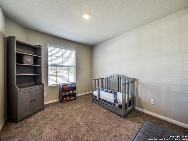 carpeted bedroom with a textured ceiling and a crib