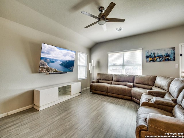 living room featuring ceiling fan, hardwood / wood-style floors, and vaulted ceiling