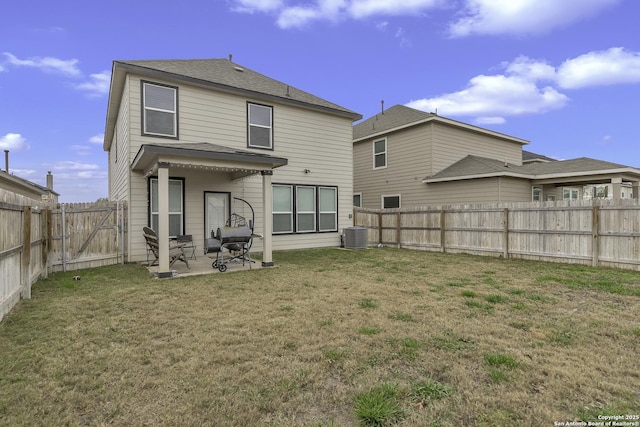 back of house with a patio area, a lawn, and central AC