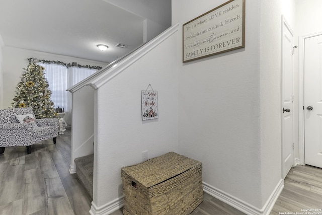 hall with hardwood / wood-style floors and crown molding