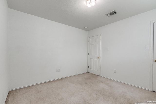 carpeted empty room with a textured ceiling