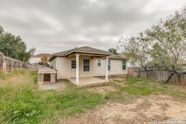 rear view of house featuring a patio area and a storage shed