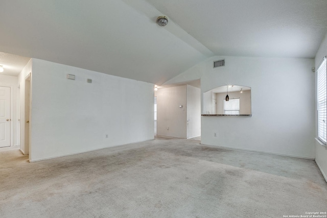 unfurnished living room featuring light carpet and lofted ceiling