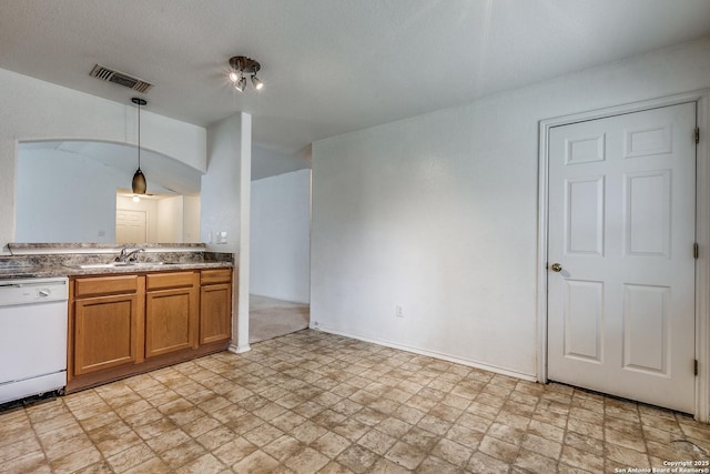 kitchen with sink, a textured ceiling, dishwasher, and hanging light fixtures