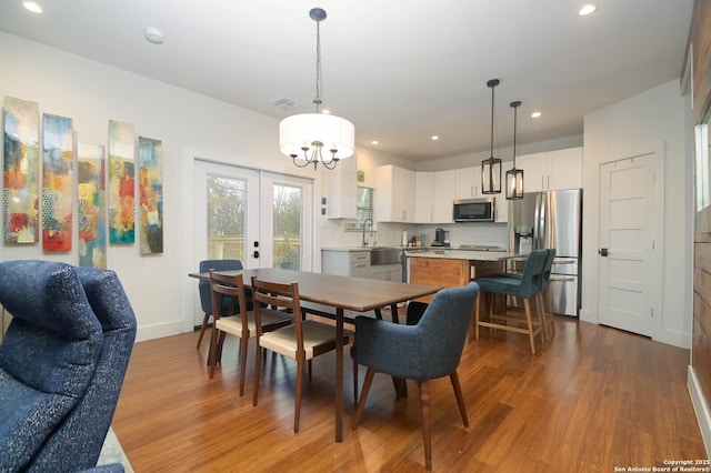 dining room featuring sink, light hardwood / wood-style floors, and french doors