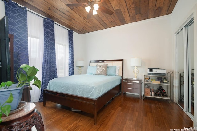 bedroom with ceiling fan, wood ceiling, dark hardwood / wood-style floors, ornamental molding, and a closet