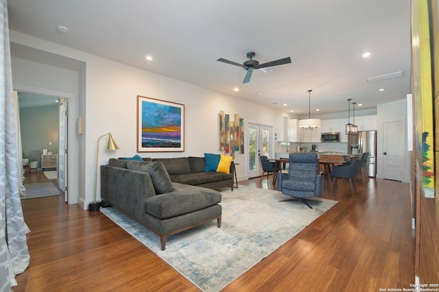 living room featuring ceiling fan and dark wood-type flooring