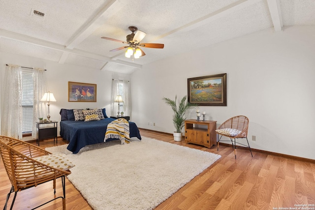 bedroom with ceiling fan, a textured ceiling, and light hardwood / wood-style flooring