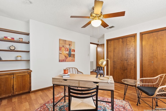 office featuring a textured ceiling, light hardwood / wood-style flooring, and ceiling fan