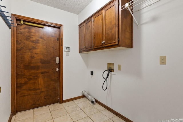 washroom with cabinets, washer hookup, and a textured ceiling