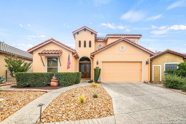 mediterranean / spanish-style house featuring a garage and french doors