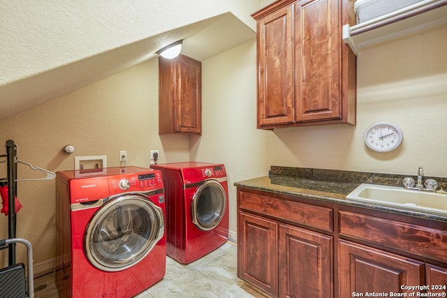 laundry area featuring sink, washing machine and clothes dryer, and cabinets