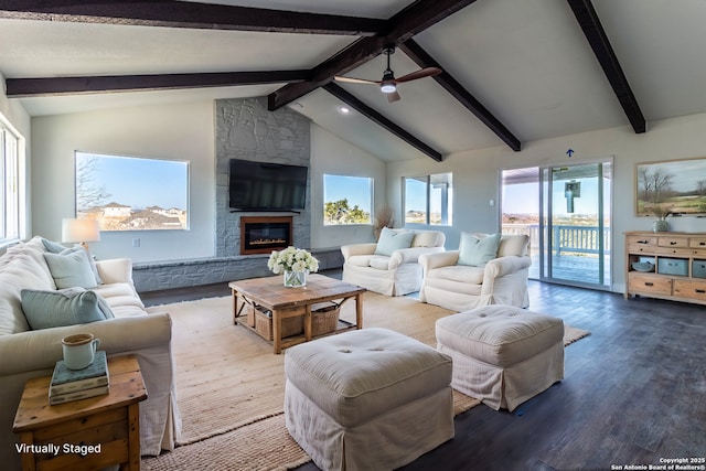 living room with wood-type flooring, beamed ceiling, a stone fireplace, high vaulted ceiling, and ceiling fan