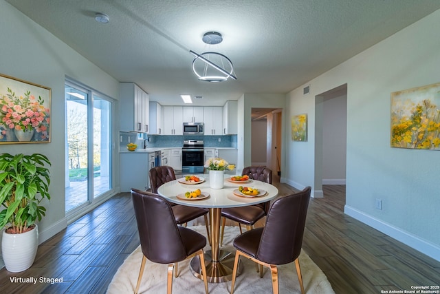 dining area featuring sink, a textured ceiling, and dark hardwood / wood-style flooring