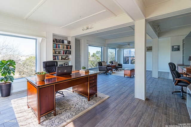 home office featuring ceiling fan, built in shelves, and a healthy amount of sunlight