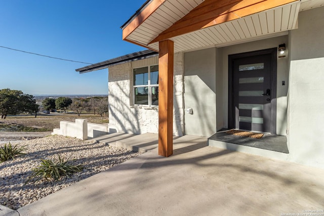 view of exterior entry featuring a patio area