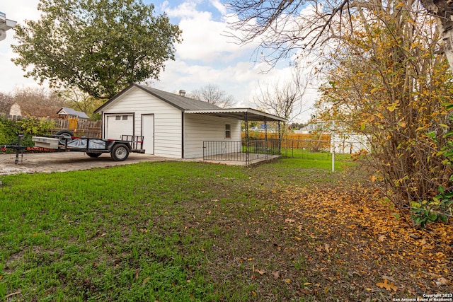 view of yard with a garage and an outbuilding