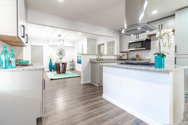 kitchen with white cabinets, a center island, island exhaust hood, and wood-type flooring