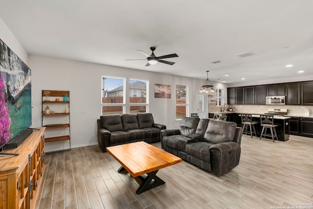 living room featuring ceiling fan and light hardwood / wood-style flooring