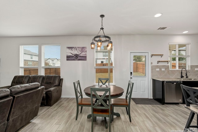 dining area with sink and light hardwood / wood-style floors