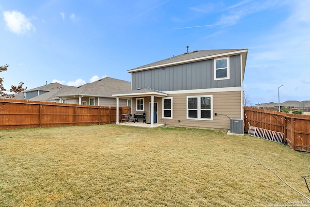 back of property featuring a patio area, a yard, and central AC