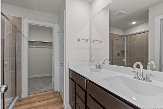 bathroom with hardwood / wood-style flooring, an enclosed shower, and vanity