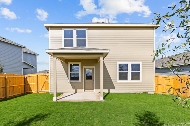 back of house with a patio area and a lawn