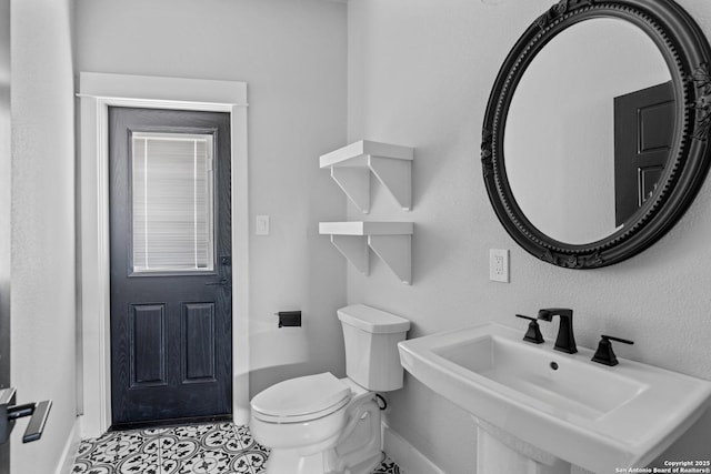 bathroom featuring sink, toilet, and tile patterned flooring